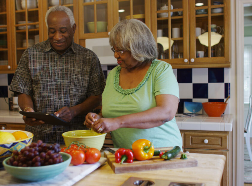 Retired black couple cooking in the kitchen
