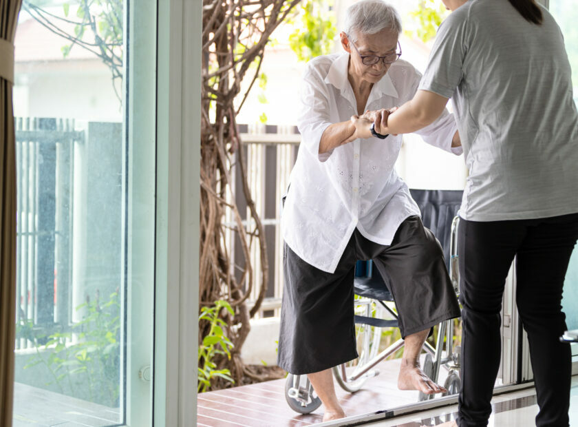 Asian caregiver help care to senior grandmother walk,woman holdi