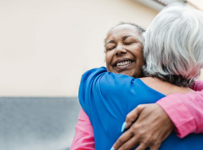 Multiracial senior women hugging each other – Elderly friendship and love concept – Focus on african woman face