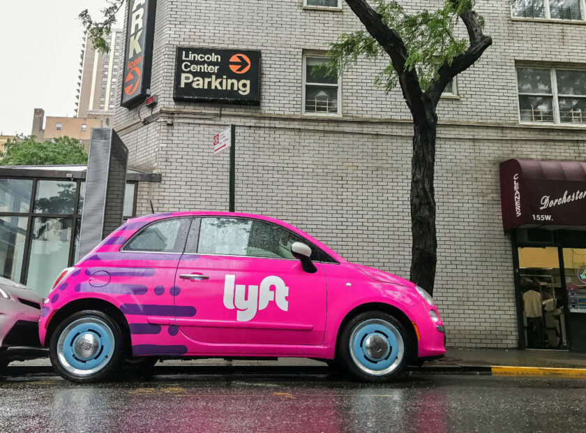 Fiat 500 painted pink and carrying a Lyft logo.