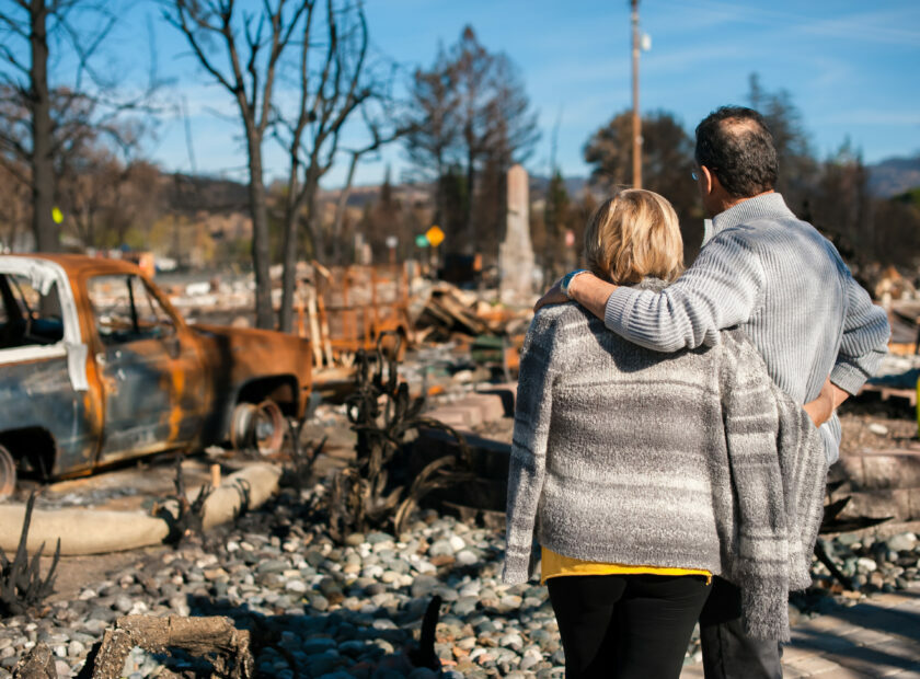 man and woman embracing while looking at ruins of a structure