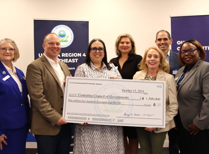 group of people holding a large check