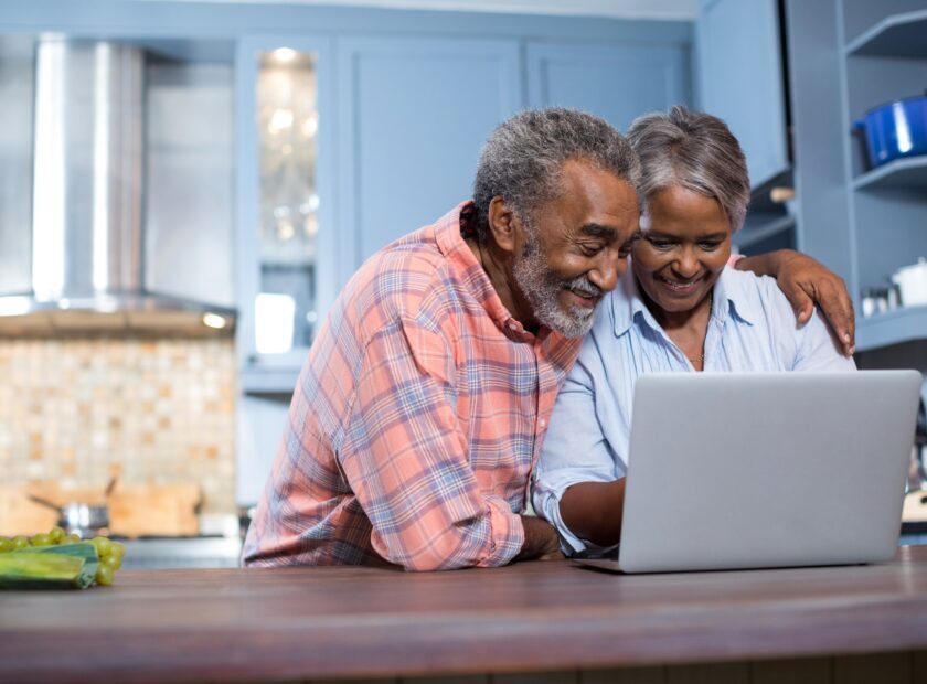 Smiling couple using laptop computer