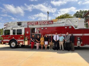 group of people standing in front of new fire truck