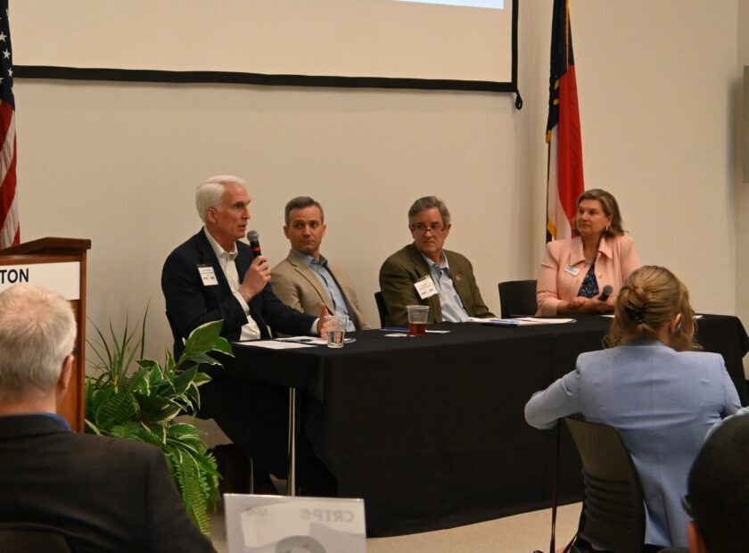 three men and one woman on a professional panel