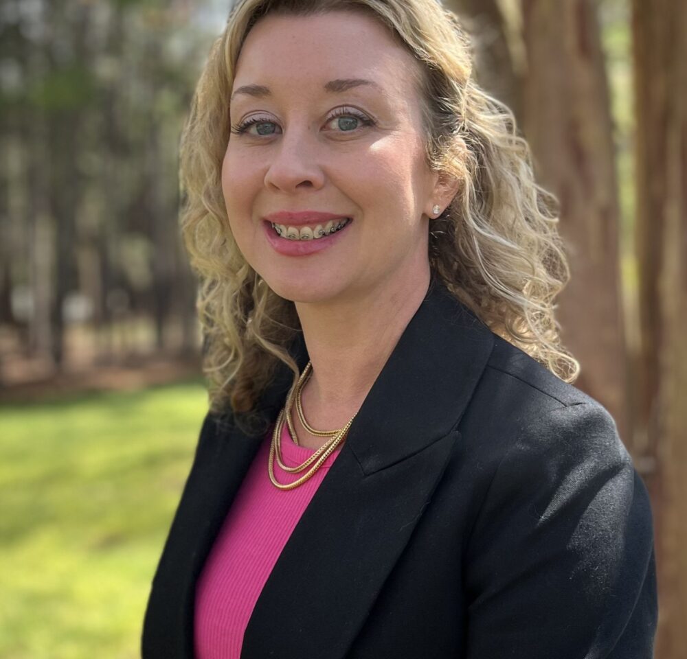 blond woman in pink shirt and black blazer